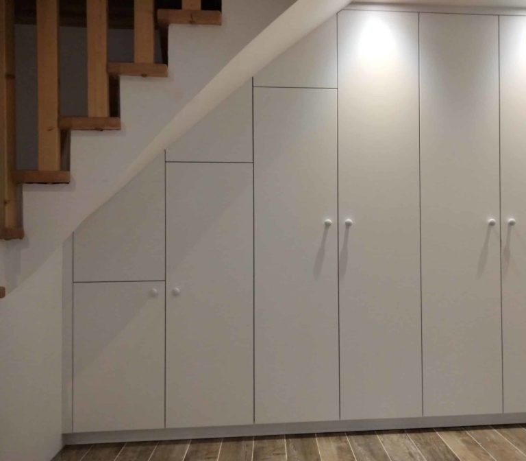 Meuble sous escalier avec 6 portes blanches. Portes ajustées à la pente de l'escalier