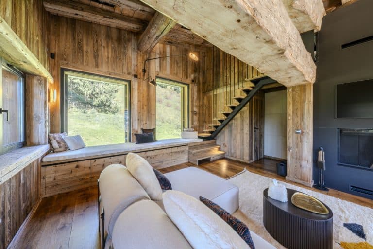 salon d'un chalet avec meuble banquette et escalier limon métal marche en vieux bois
